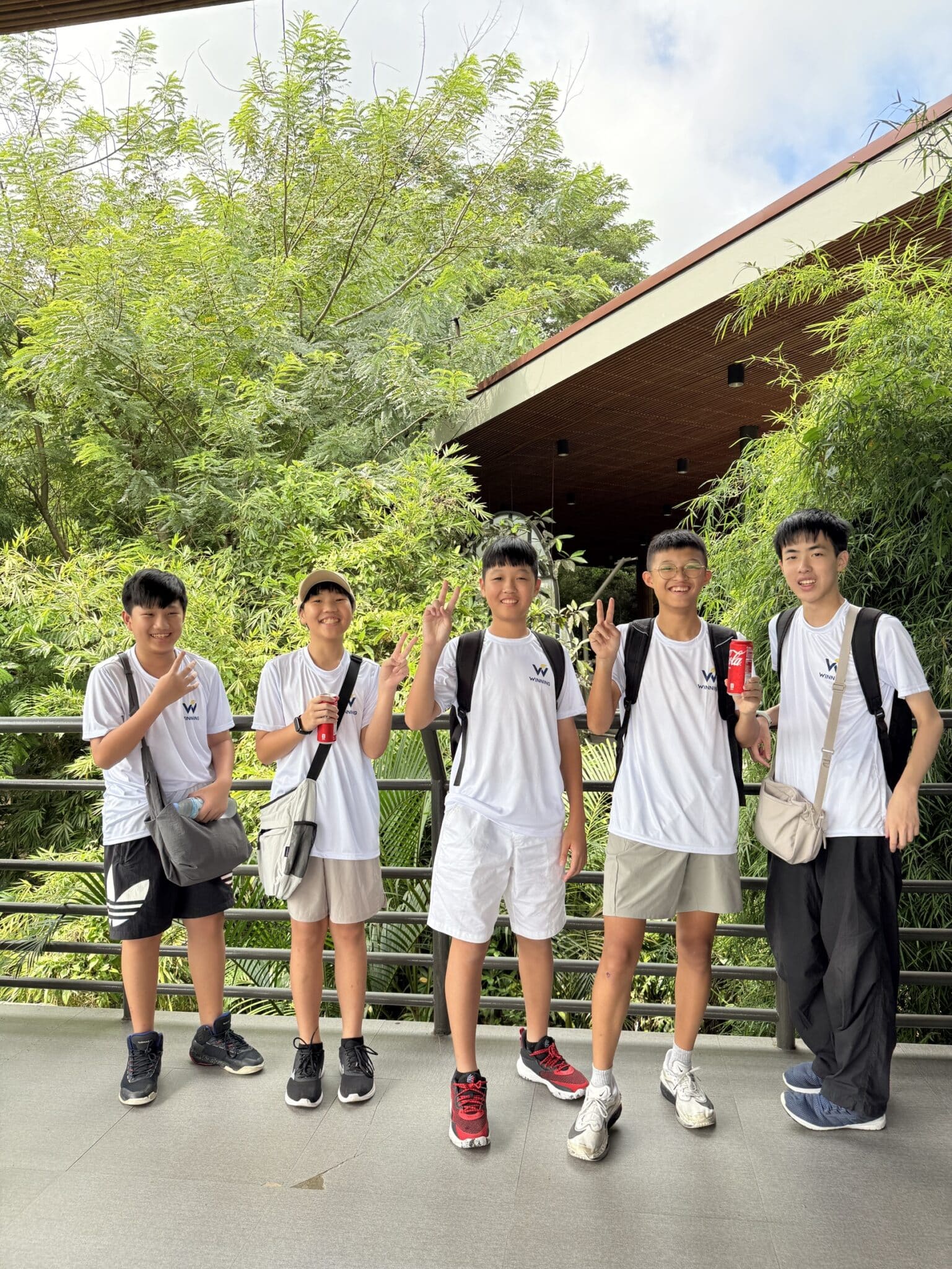 青少年小朋友在動物園入口合影比手勢
