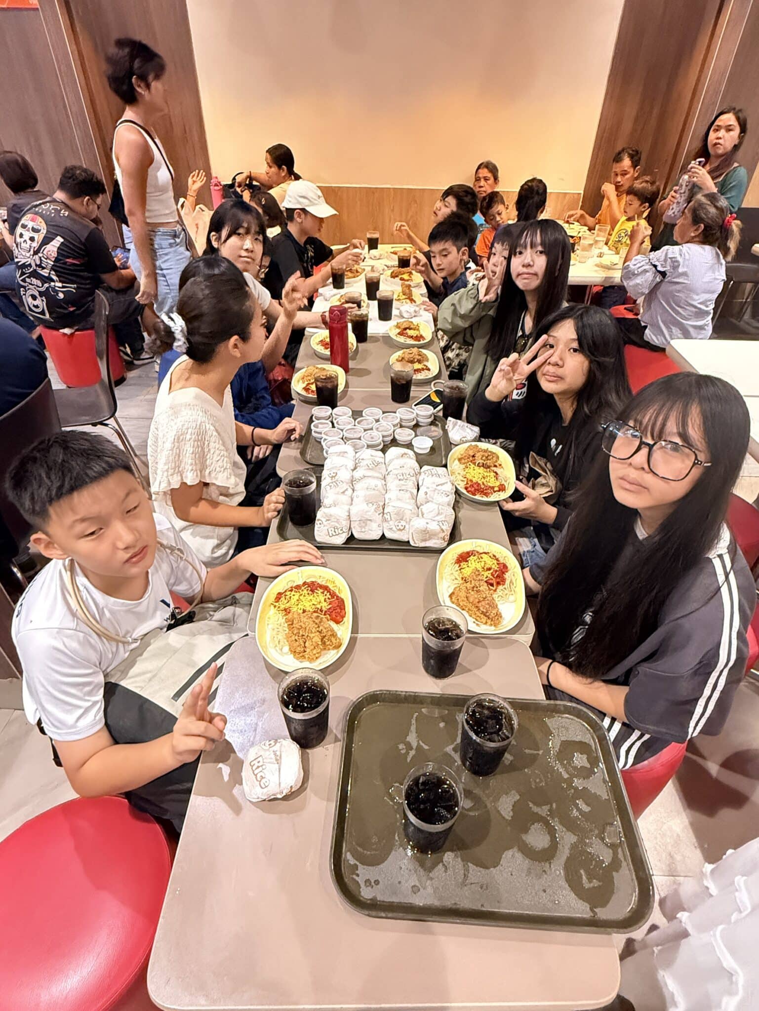 學生們圍坐長桌一起享用餐點並分享採買心得